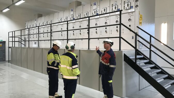 Engineers in front of new high-voltage switchgear at Elkem Fiskaa in Kristiansand